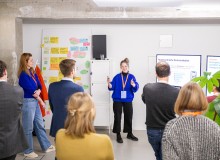 Mehrere Besucher:innen des Demo Day hören bei einer Präsentation zu