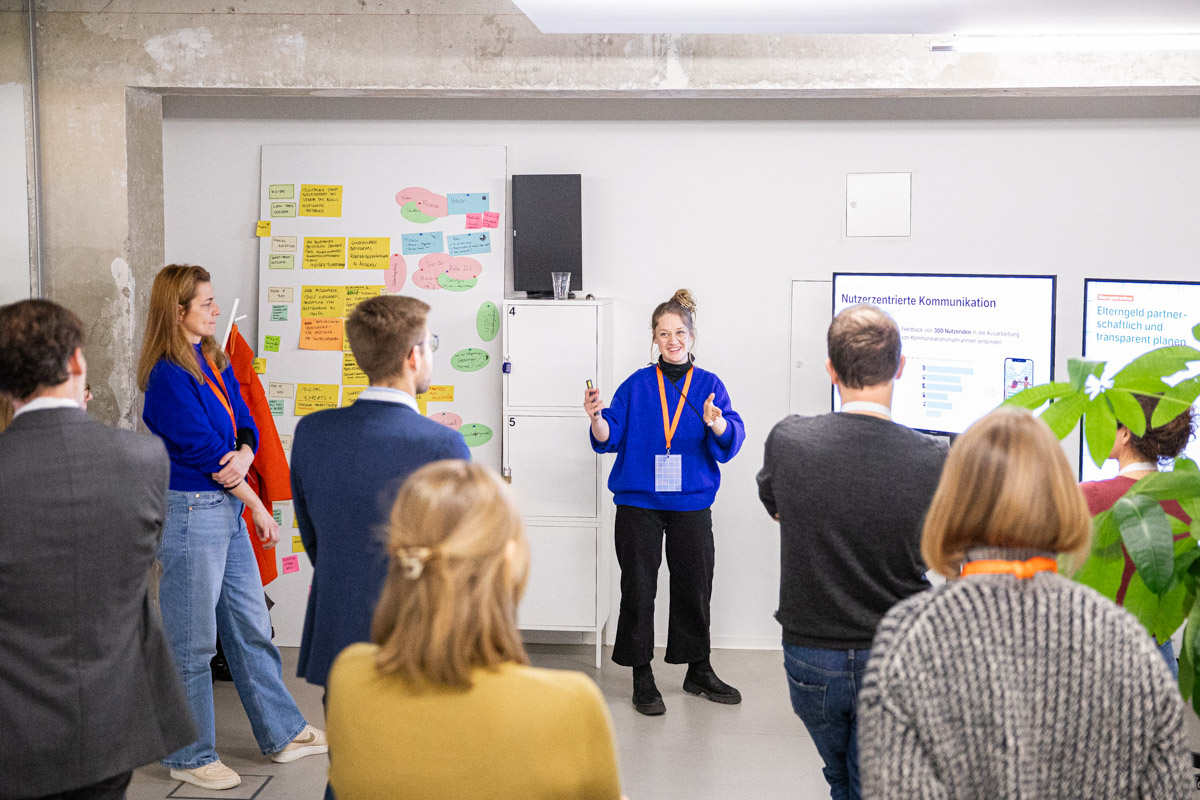 Mehrere Besucher:innen des Demo Day hören bei einer Präsentation zu