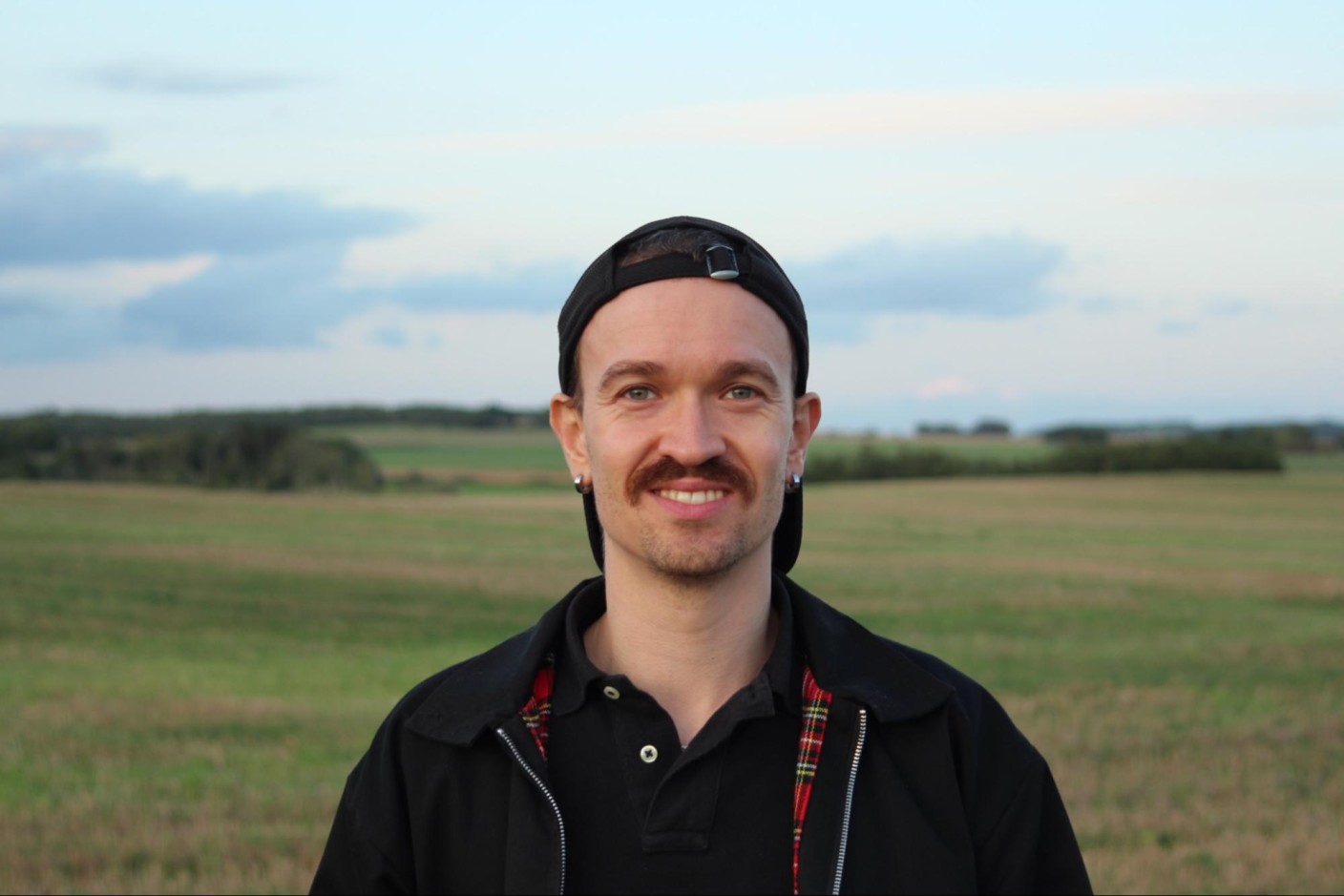 A photo of Thomas Miebach in front of a green field