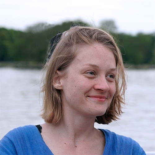 A photo of Marie Beckmann in front of a river or lake