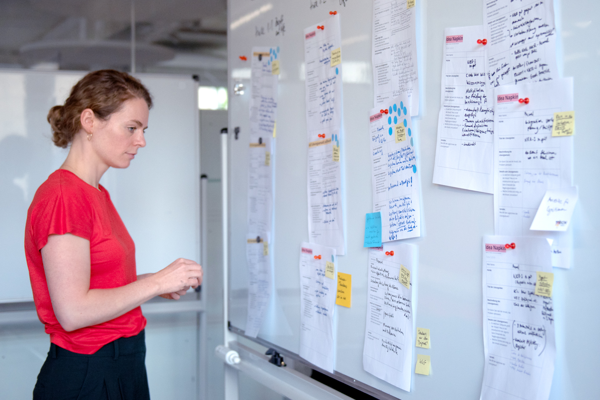Eine Mitarbeiterin des DigitalService betrachtet Notizen an einem Whiteboard