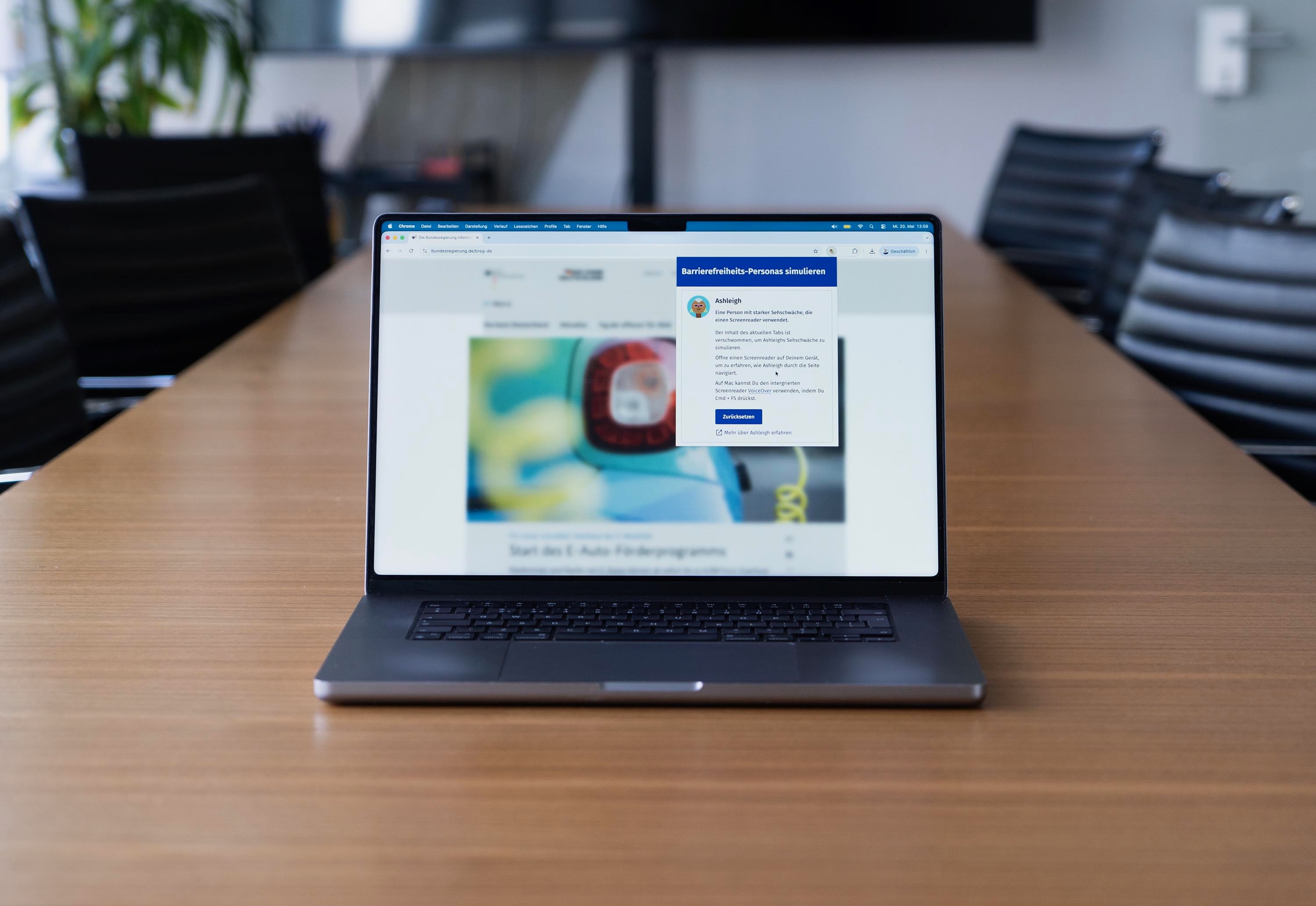Laptop-Computer auf einem Tisch, der eine stark unscharf abgebildete Webseite in einem Web-Browser anzeigt mit einem Fenster darüber – zu einer stark seheingeschränkten Barrierefreiheits-Persona namens Ashleigh