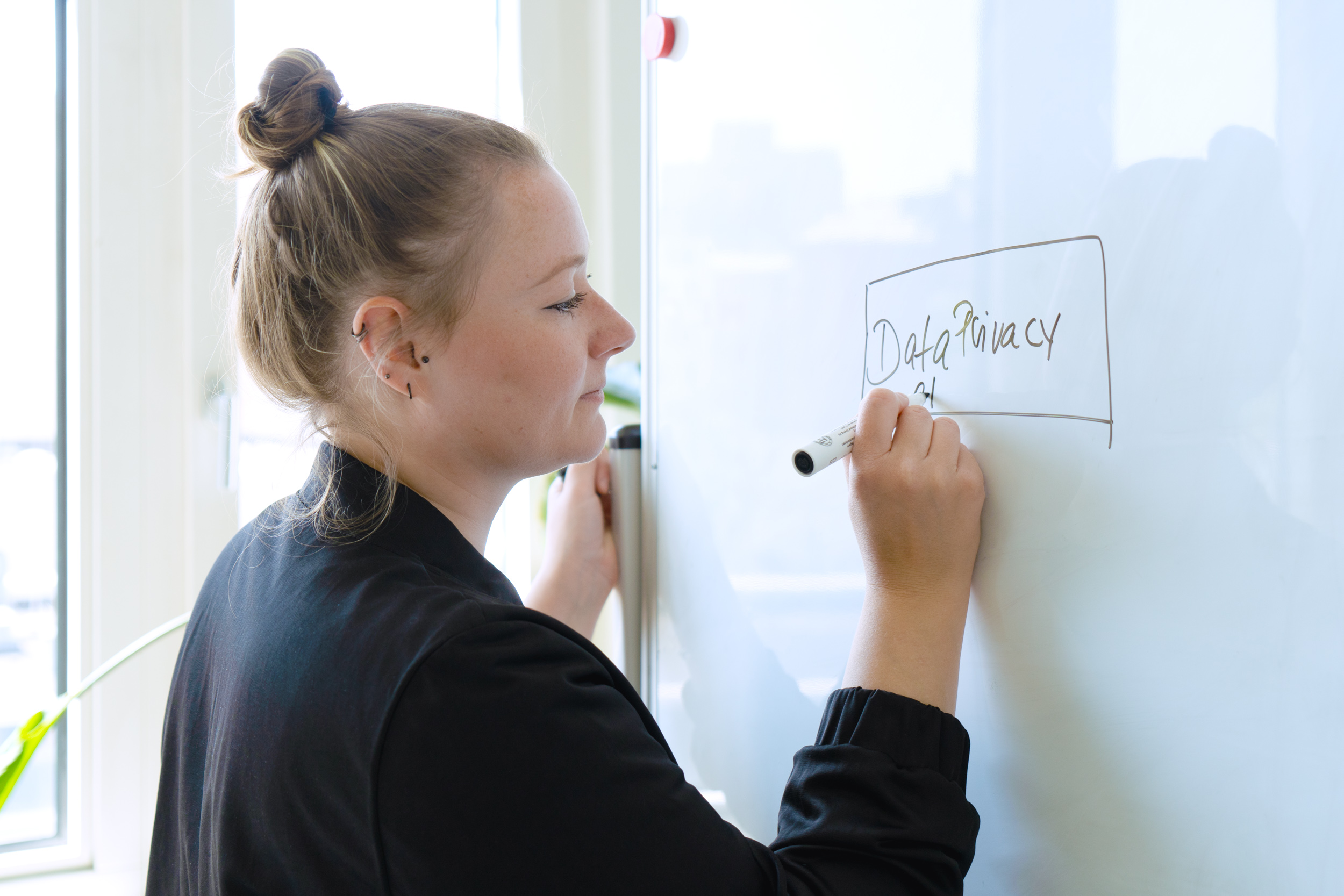 Autorin Franziska schreibt die Worte „Data Privacy“ (auf Deutsch „Datenschutz“) an ein Whiteboard
