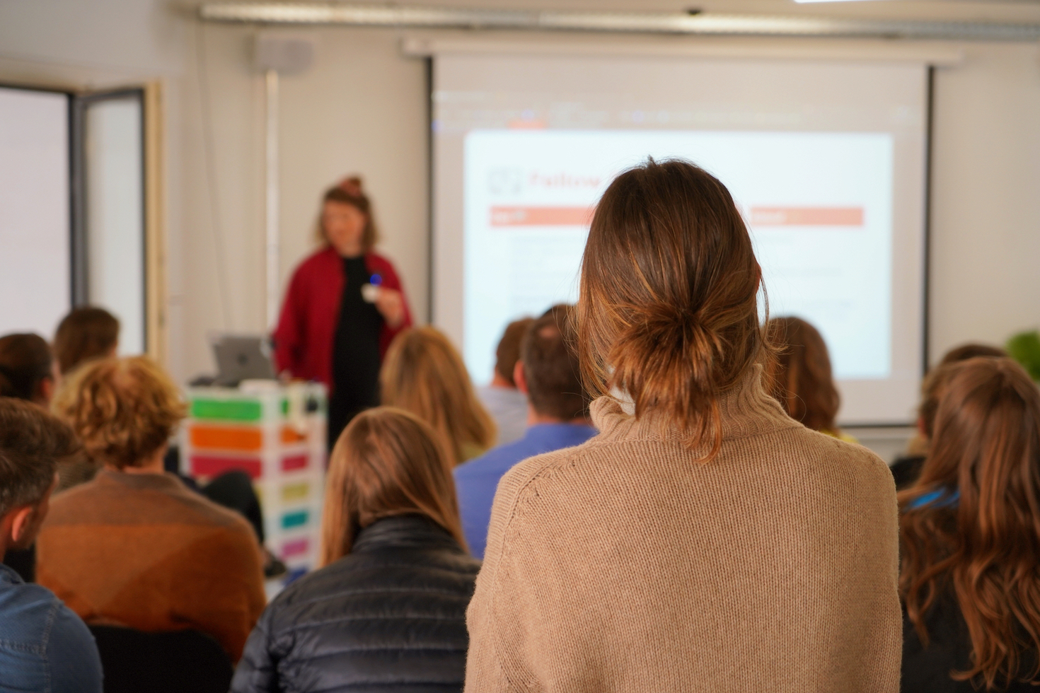 Szene aus den Fellowships: Teilnehmende sitzen im Plenum und hören einem kurzen Input zu.
