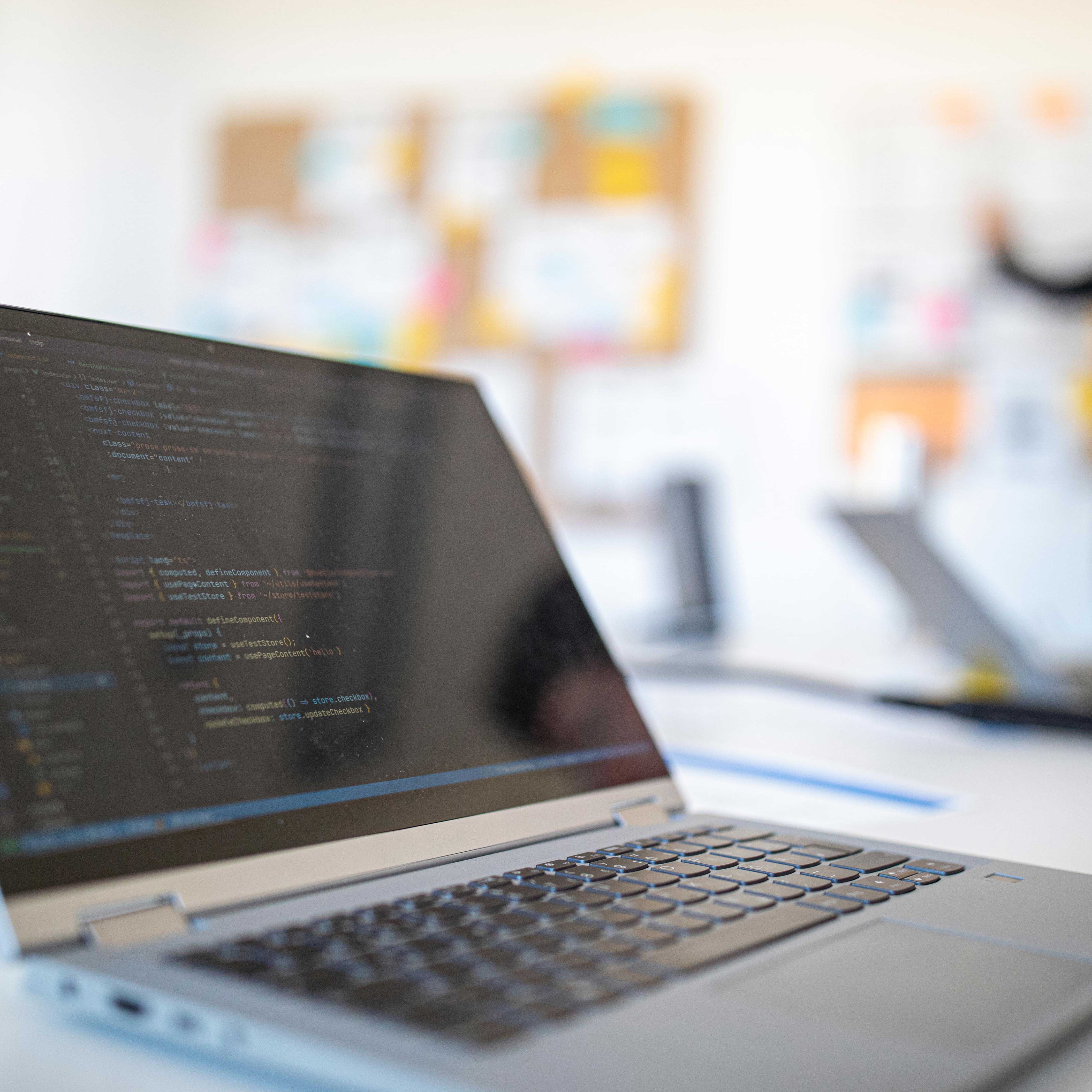 Aufgeklappter Laptop mit Code auf dem Bildschirm