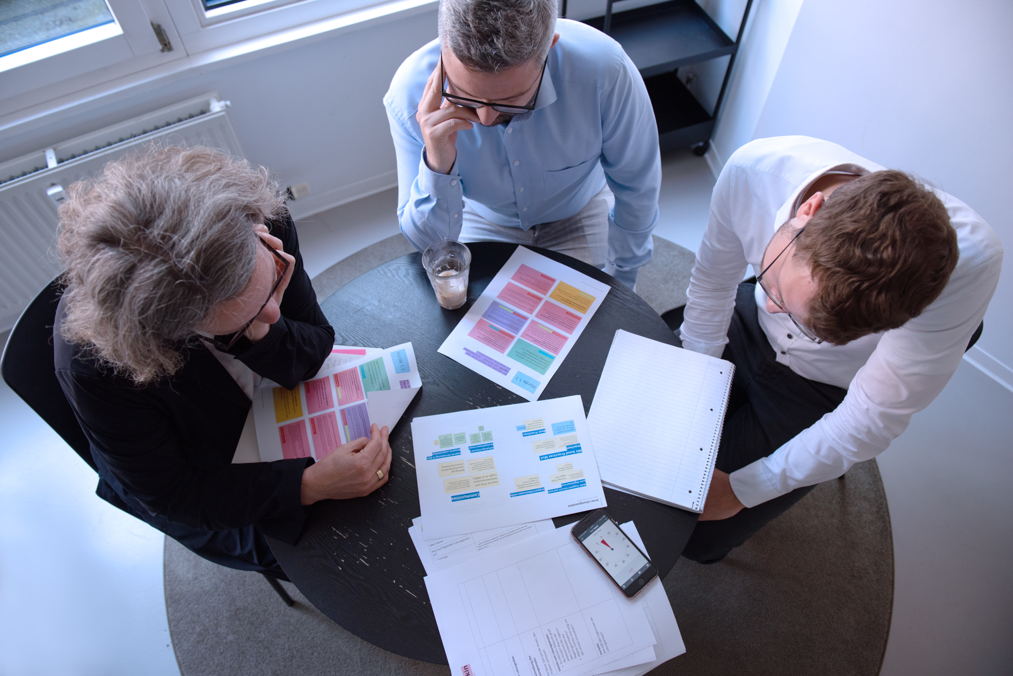 Drei Teilnehmer der interministeriellen Arbeitsgruppe im Rahmen des Digitalcheck an einem Tisch.